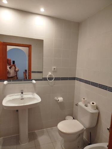 a bathroom with a toilet and a sink and a mirror at TorrelagunaVera in Palomares