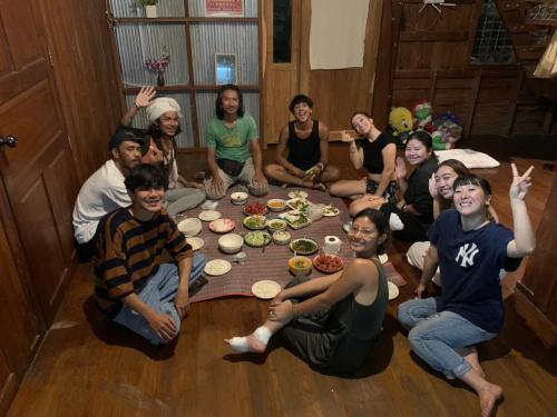un grupo de personas sentadas alrededor de una mesa en Yor Song Hostel Pai, en Ban Huai Pu