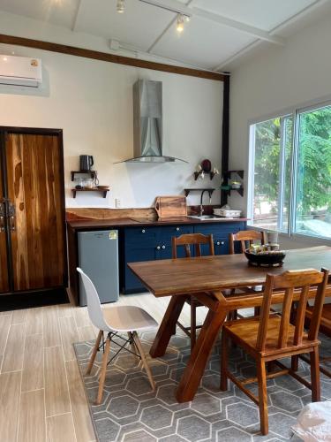 eine Küche mit einem Holztisch und Stühlen in der Unterkunft Phimai Pond House in Pi Mai
