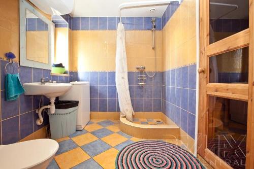 a blue tiled bathroom with a sink and a toilet at Auli Beach Area Holiday Home in Pärnu