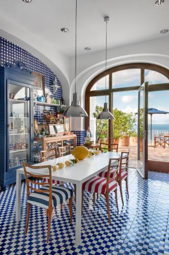 a dining room with a white table and chairs at Maison La Minervetta in Sorrento