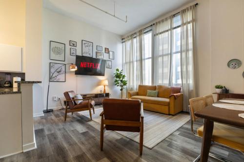a living room with a couch and a table at Indy Urban Nest - Sleeps 8 - Skywalk Access - Convention Center - Stadium in Indianapolis