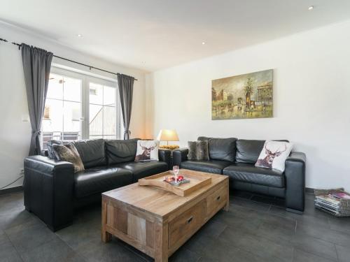 a living room with a couch and a coffee table at Holiday Home Brixen near Skiwelt Slopes in Brixen im Thale