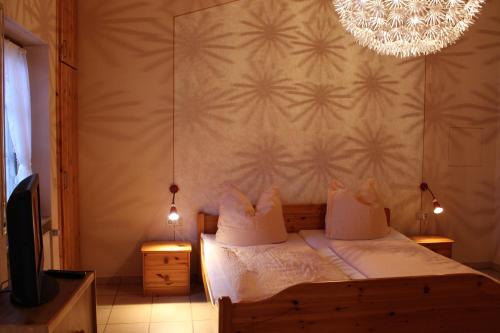 Schlafzimmer mit einem Bett und einem Kronleuchter in der Unterkunft Weingut Loescher in Senheim