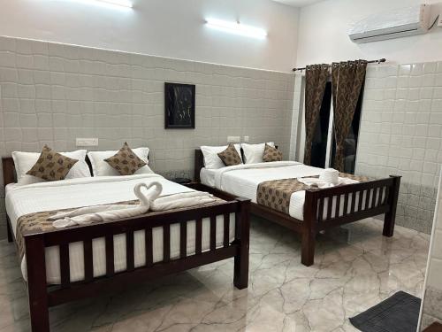 a bedroom with two beds with towels on them at Luxus Resort in Puducherry