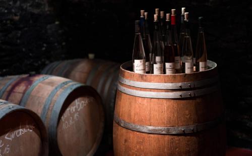 a wooden barrel filled with bottles of wine at Weingut Loescher in Senheim