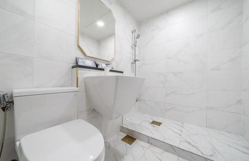 Kyŏngp'o-malにあるAJ Hotelのトイレとシャワー付きの白いバスルーム