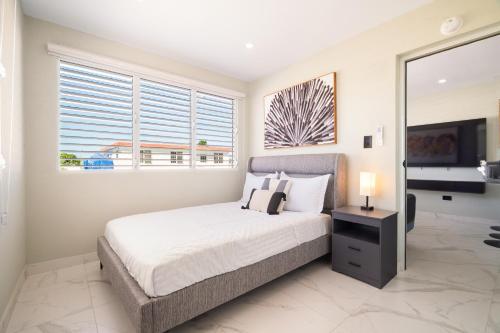 a bedroom with a bed and a large window at 2bedroom Lux house Isla Verde with Private Patio by PH in Carolina