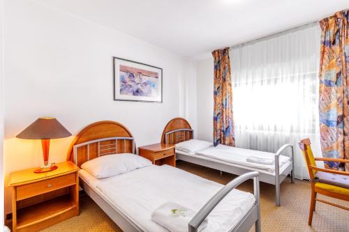 een kamer met twee bedden en een raam bij Hotel CHOTOL in Horoměřice