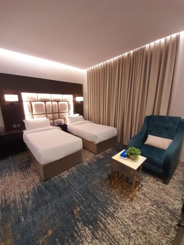 a hotel room with a bed and a couch and a chair at شقق رويال العلا الفندقية in AlUla