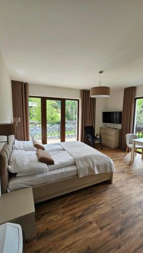 ein Schlafzimmer mit großem Bett und ein Wohnzimmer in der Unterkunft Willa Zacisze Szczawnica 25 m2 in Szczawnica