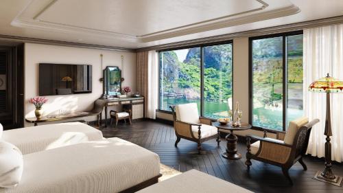 ein Schlafzimmer mit einem Bett und einem Tisch mit Stühlen in der Unterkunft L'amour Cruise Halong 2 in Hạ Long