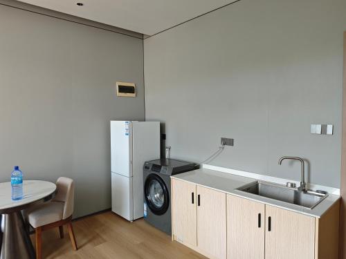 a kitchen with a sink and a refrigerator and a table at Grace Hotel in Honiara