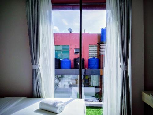 a bedroom with a window with a view of a building at Q3 Inn in Semporna