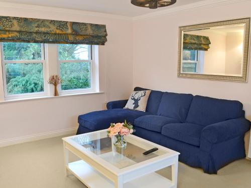 un salon avec un canapé bleu et une table dans l'établissement Tower Cottage - Mvw, à Belsay