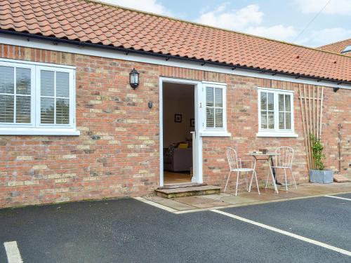 een stenen huis met een tafel en stoelen ervoor bij Croft Cottage 1 - Uk10587 in Stillington