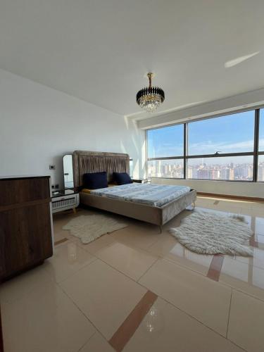 a large bedroom with a bed and a large window at Appartement haut standing a mobilart in Oran