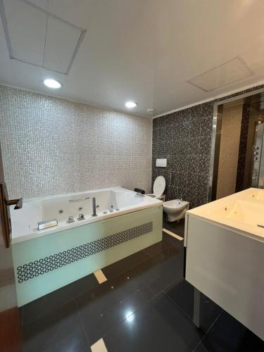 a large bathroom with a tub and a toilet at Appartement haut standing a mobilart in Oran