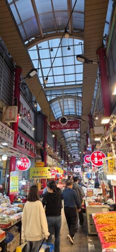 a group of people walking through a market at 연 스테이 in Seoul