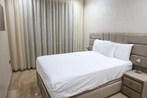 达布阿扎Dar Bouazza Luxury apartment with pools garden sports courts parking near the sea的卧室里有一张白色的大床，配有白色的枕头