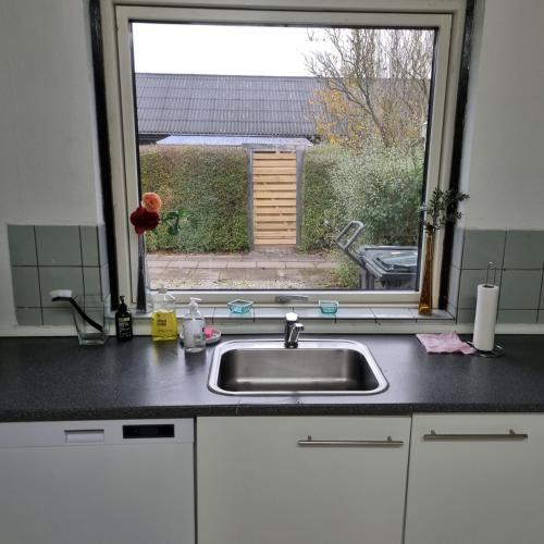 a kitchen counter with a sink and a window at Joysha's House in Ikast