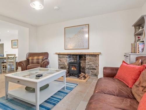 a living room with a couch and a fireplace at Morfa Ganol in Llangranog
