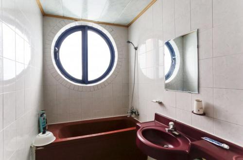 江陵市にあるGyeongpo Comodo Motelのバスルーム(赤いシンク、バスタブ付)