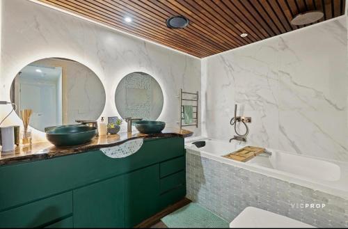 bagno con 2 lavandini e vasca di Penthouse Retreat in Heart ofCBD a Melbourne