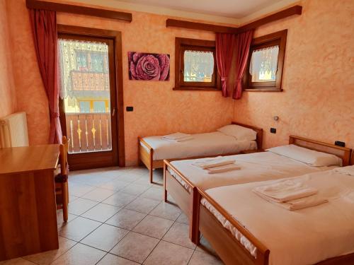 a room with two beds and a window at Baita Stella Alpina in Livigno