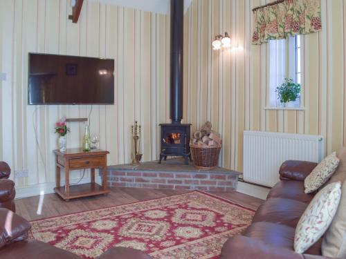 ein Wohnzimmer mit Couch und Kamin in der Unterkunft Carthouse Cottage in Carew