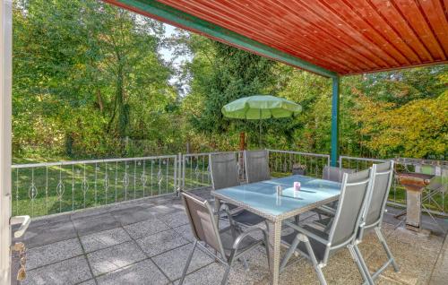 a patio with a table with chairs and an umbrella at Ferienhaus Boitzenburger Land in Rosenow