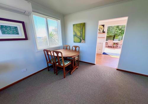 a dining room with a wooden table and chairs at Top of Tyne - Peace, Comfort & Local Connection in Oamaru