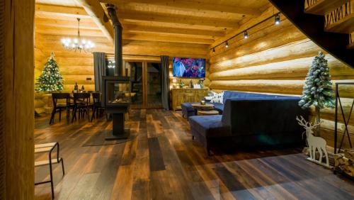 a living room with a couch and a table with a christmas tree at Chata Czego Dusza Pragnie in Zachełmie