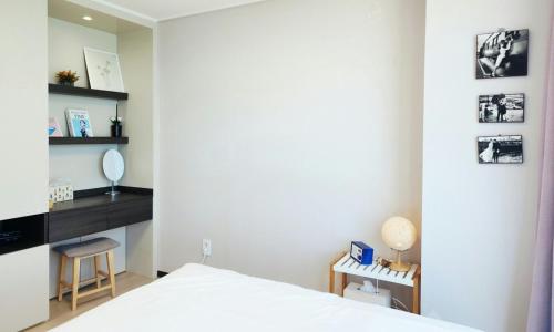 a bedroom with a bed and a desk and a mirror at an emotional view of the sea at sunrise in Kwangan-dong