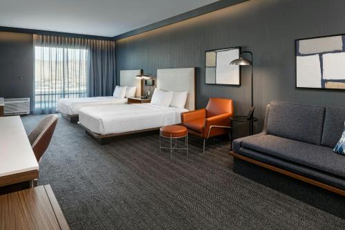 a hotel room with two beds and a couch at Courtyard Lewiston in Lewiston