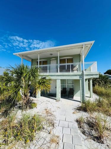 a house on the beach with chairs and trees at North Shore Duplex #54588 Duplex in Anna Maria