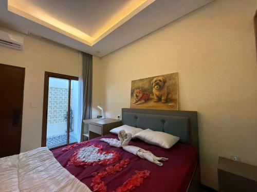 a bedroom with a bed and a painting of a dog at villa koku kuta in Legian