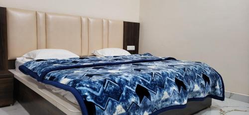 a blue and white comforter on a bed in a room at Hotel Premshanti Orchha in Orchha
