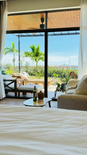 a living room with a bed and a view of the ocean at LÚA de ROSY HOI AN in Hiếu Nhơn