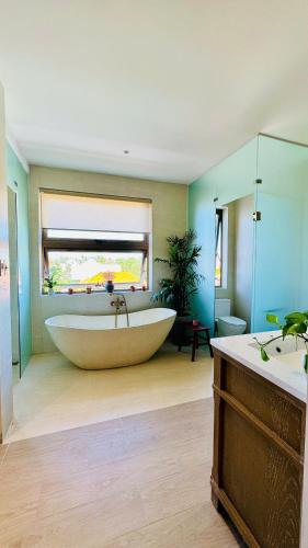 a large bathroom with a large tub and a window at LÚA de ROSY HOI AN in Hiếu Nhơn