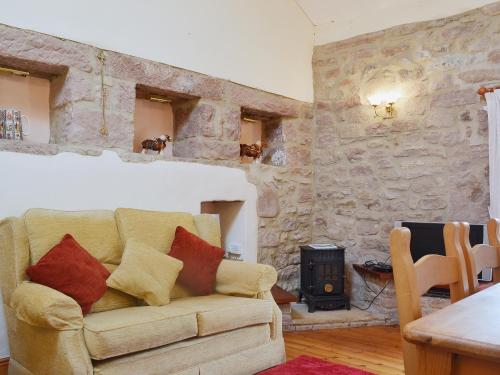 a living room with a couch and a stove at Barn Owl Cottage in Cromford