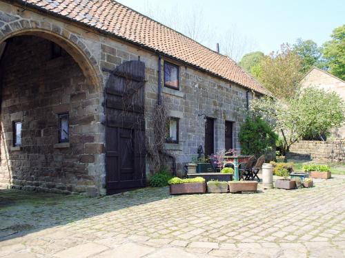 a brick building with a door and a patio at Threshing Barn - Kza in Glaisdale