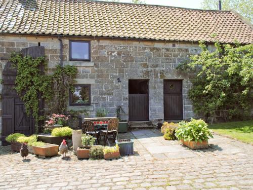 a stone house with chickens standing in front of it at Threshing Barn - Kza in Glaisdale