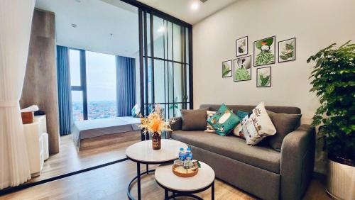 a living room with a couch and a table at Ecopark Homestay - Căn hộ studio, 1 ngủ, 2 ngủ, 3 ngủ - Bể bơi, phòng gym, tắm khoáng Onsen in Kim Quan