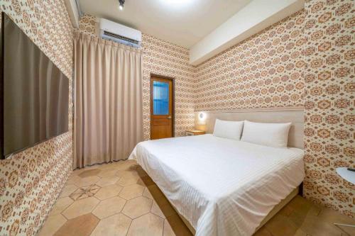 a bedroom with a white bed and a sink at Yunhua B&B in Hualien City