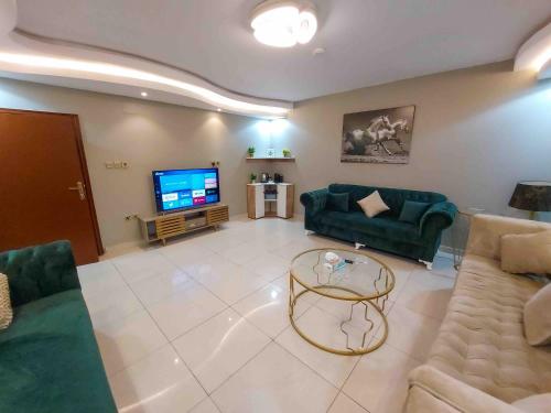 ジッダにあるMira AlSafaのリビングルーム(緑のソファ、テレビ付)