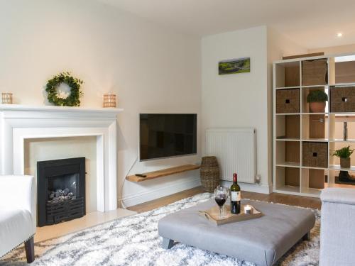 a living room with a fireplace and a tv at Dales Retreat in Skipton