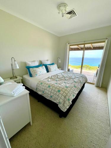 a bedroom with a bed with a view of the ocean at Blue Haven Beach House - Guest Suite I