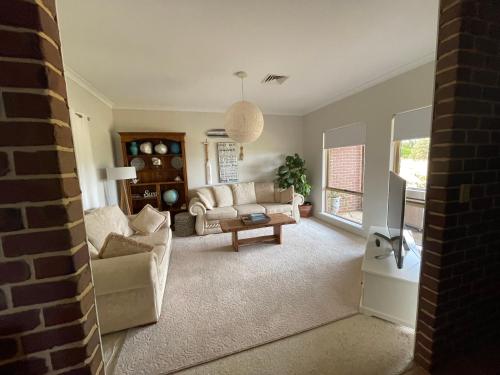 a living room with a couch and a tv at Blue Haven Beach House - Guest Suite I 