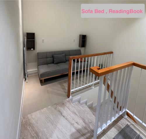 a living room with a couch and a stair case at Ho tram Beach Villa Biển Xuyên Mộc in Xuyên Mộc